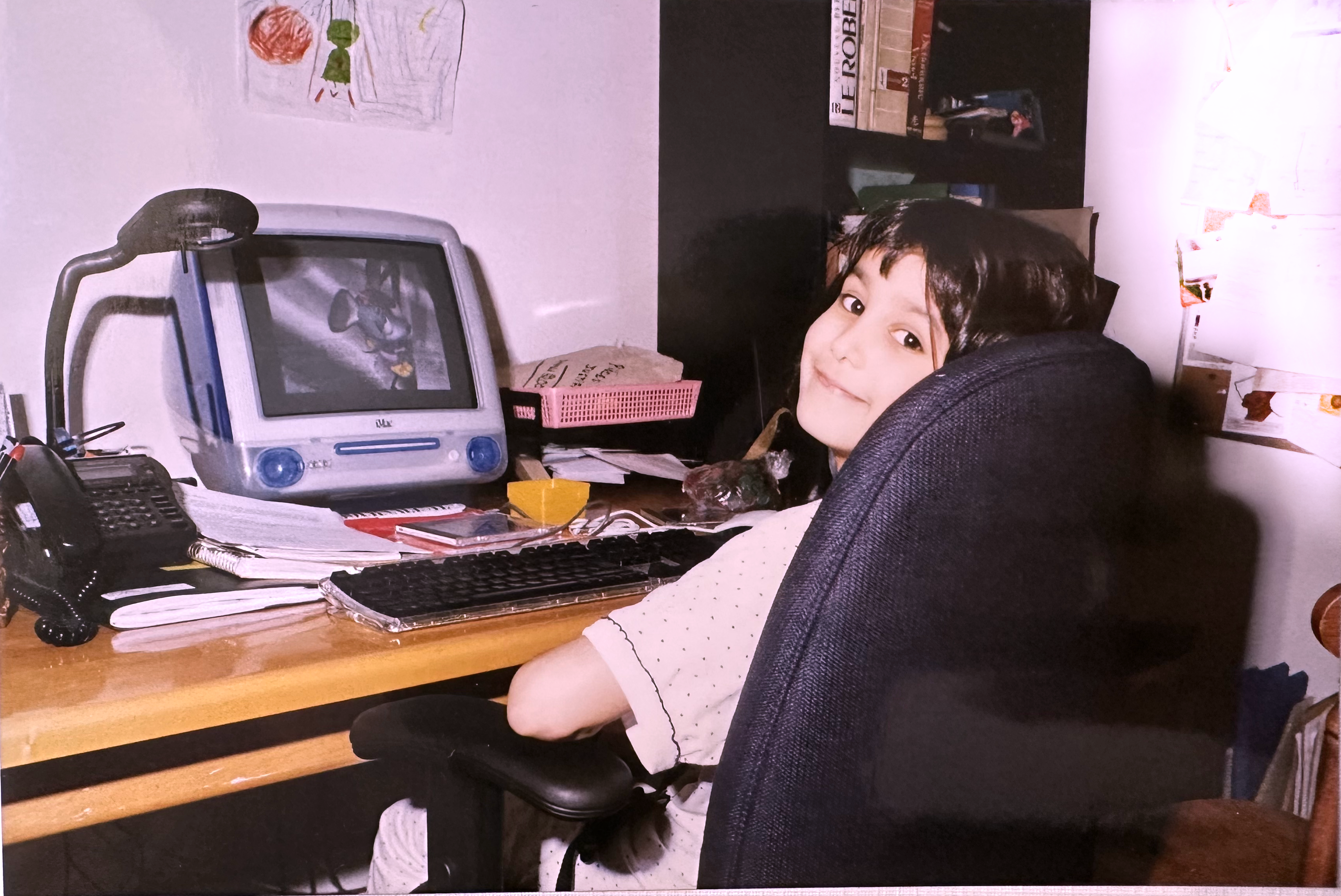 Alyssa sitting in front of her Apple Macintosh iMac G3 computer in the colour Indigo.